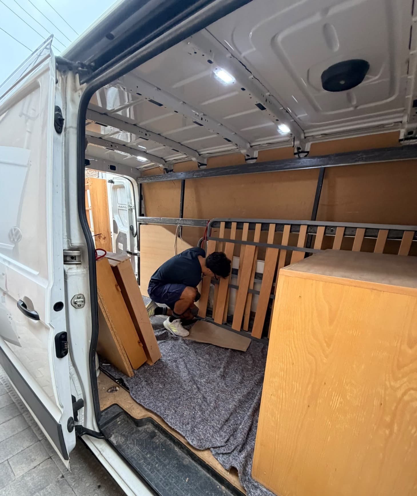 Operario de Campsil asegurando una cama desmontada y un armario dentro de la furgoneta en Barcelona