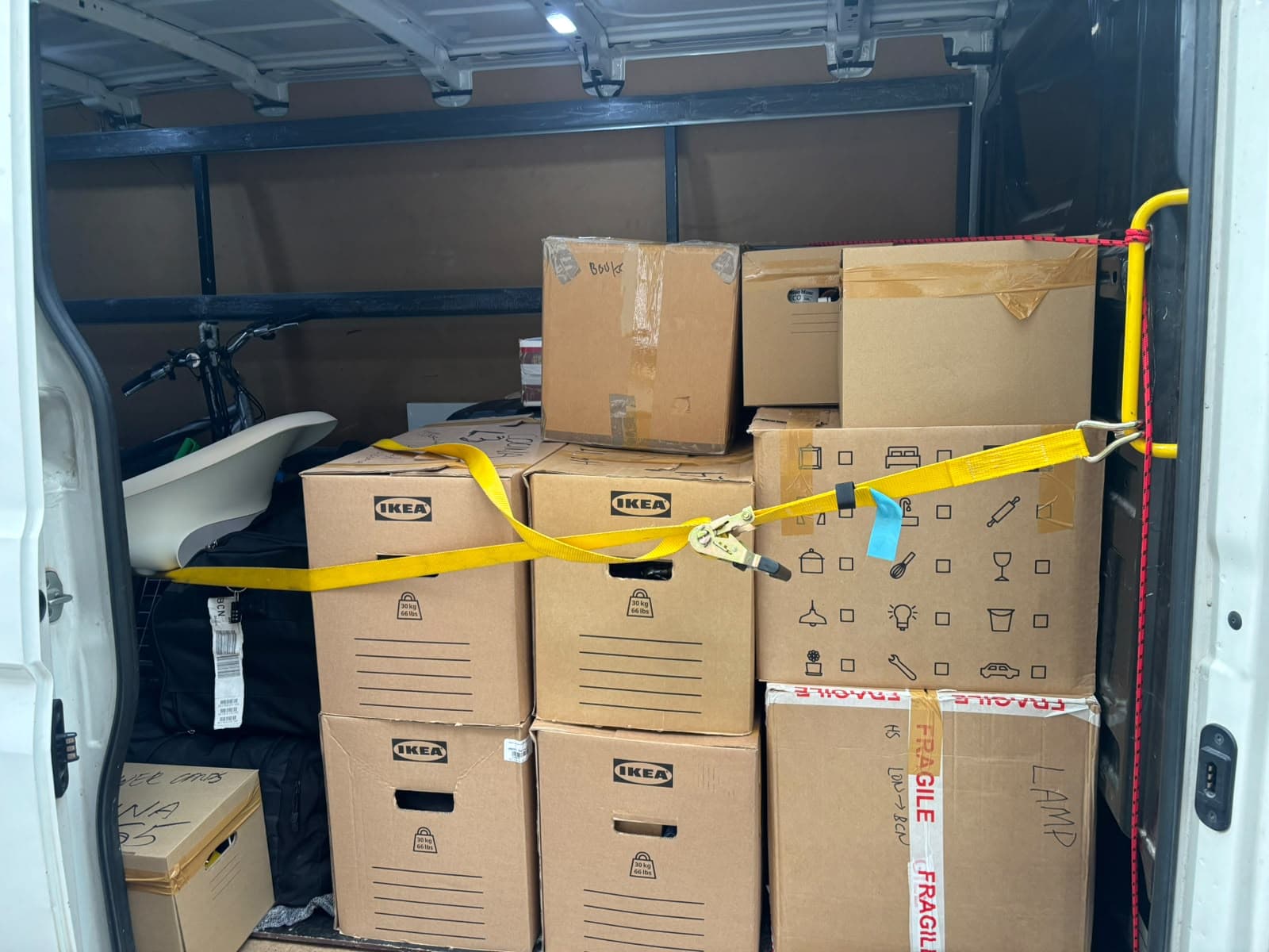 Mudanza pequeña en Barcelona: cajas IKEA y enseres sujetos con correa en la furgoneta de Campsil